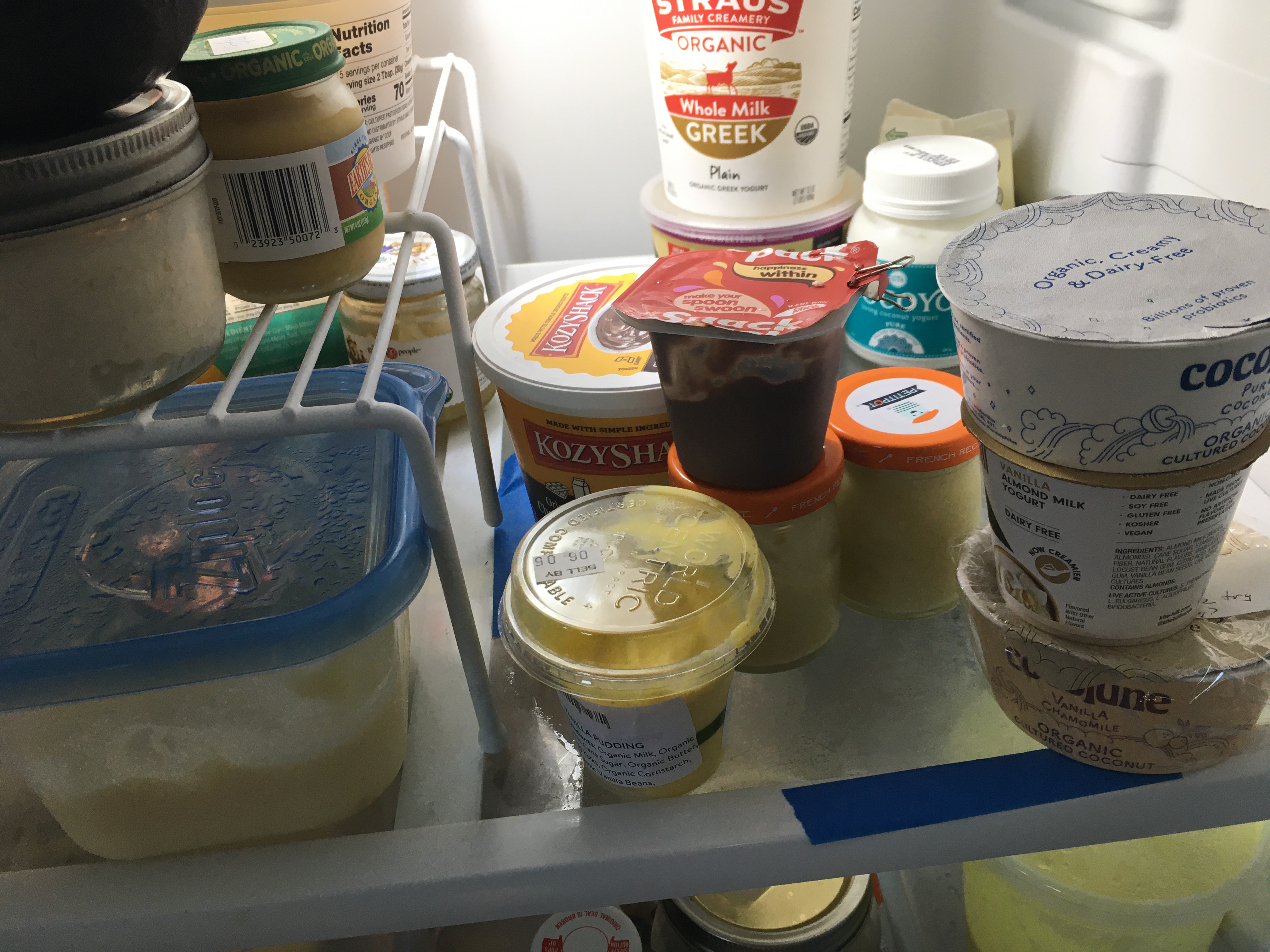 Photo of fridge showing containers of different puddings and yogurts
